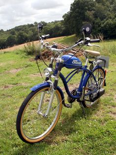 a blue and yellow bicycle parked in the grass