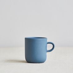 a blue cup sitting on top of a white table