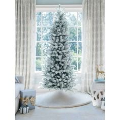 a white christmas tree in front of a window