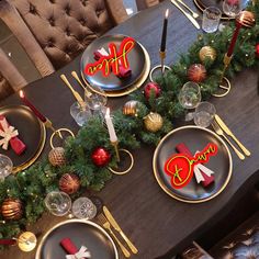 a table set for christmas with plates and candles