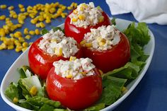 three stuffed tomatoes with corn on the cob and lettuce in between them