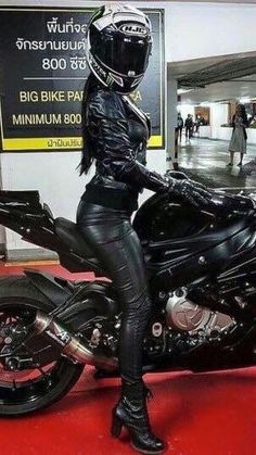 a woman sitting on top of a black motorcycle