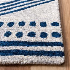 a blue and white area rug on a wooden floor with a wood floor in the background