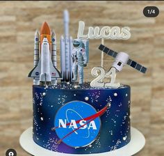 a nasa themed birthday cake with rockets and stars on the top is for lucas 24