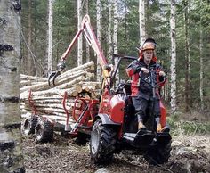 a man riding on the back of a red tractor