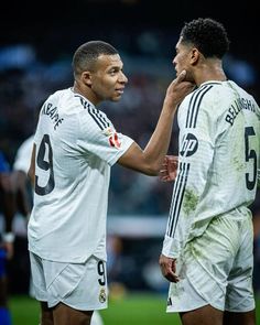 two soccer players standing next to each other on a field