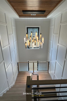 an empty room with some lights hanging from the ceiling and stairs leading up to it