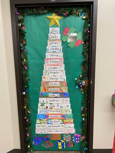 a christmas tree made out of children's books in front of a bulletin board