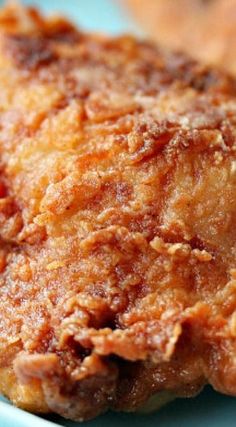 fried chicken on a blue plate with some bread in the backgroung area