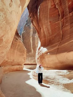 a person standing in the middle of a narrow canyon