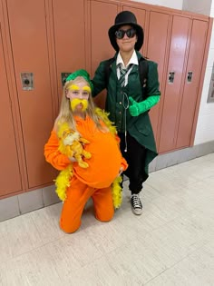 two people dressed in costumes standing next to each other near lockers with doors behind them