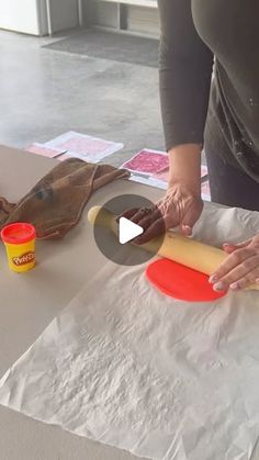 a woman rolling out dough on top of a table with other food items around her