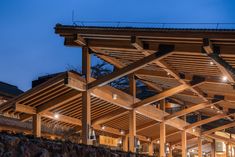 a building with wooden beams and lights at night