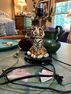 a small tiger figurine sitting on top of a table next to a lamp