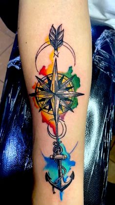 a colorful tattoo with an anchor and compass on it