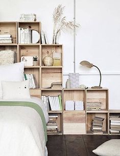 a bed room with a neatly made bed next to a book shelf