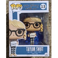 the pop vinyl figure is wearing glasses and holding a guitar picker in her hand