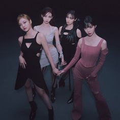 four women in black and pink outfits posing for the camera with their hands on each other's hips