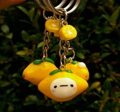 a key chain with two lemons hanging from it's ends and a face on the end