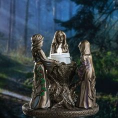 three figurines sitting on top of a tree stump