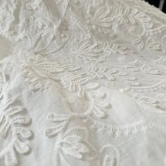 an embroidered white fabric with flowers on it