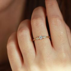 a woman's hand with a diamond ring on it