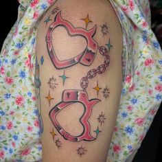 a woman with a tattoo on her arm that has two hearts and a chain attached to it