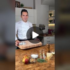 a man standing in front of a cutting board with cheese and other ingredients on it