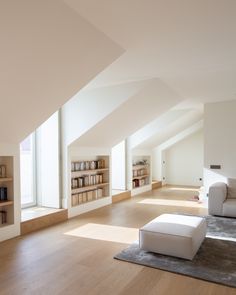 an empty living room with white furniture and bookshelves