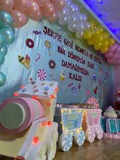 a birthday party with balloons and decorations on the wall, along with an ice cream cart