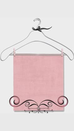 a pink cloth hanging on a clothes hanger with a black and white ribbon attached to it