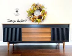 a black and brown cabinet with a wreath on top