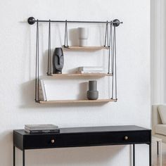 a black table with two shelves on it and a white chair in the back ground