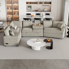 a living room filled with furniture next to a dining room table and chairs on top of a rug