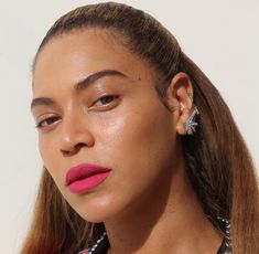 a close up of a woman with pink lipstick and jewelry on her neck, looking off to the side