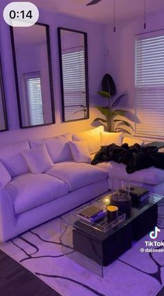 a living room with white furniture and purple lighting