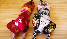 two dogs made out of fabric sitting on top of a wooden table