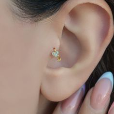 a close up of a person's ear with an earring in the shape of a star