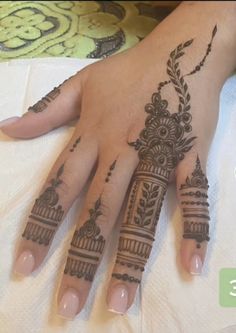 a woman's hand with henna tattoos on it