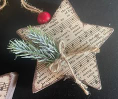 an ornament made out of old sheet music notes and a christmas tree branch