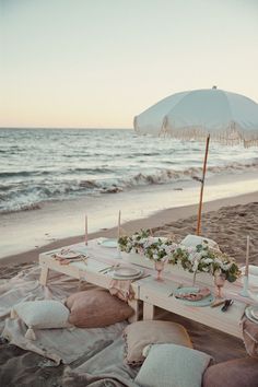 a table set up on the beach with an umbrella