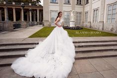 a woman in a white wedding dress standing on some steps outside a large building with stairs