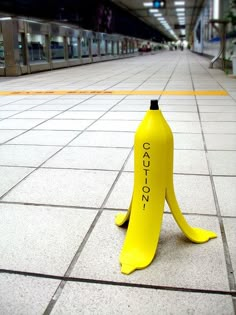 a banana sitting on the ground in front of a subway station with words written on it