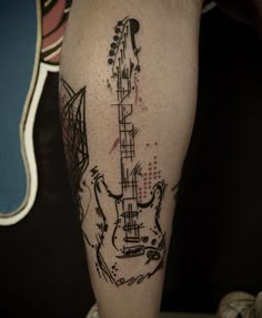 a man's leg with a guitar tattoo on the left side of his arm