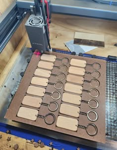 a machine that is making wooden circles on a piece of wood with scissors and wire