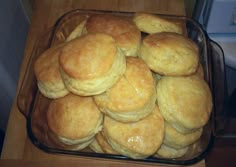 a glass dish filled with biscuits on top of a wooden table