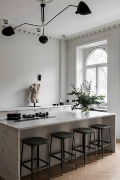 a kitchen with marble counter tops and stools