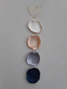 four different shapes of seashells on a white surface with a heart in the middle