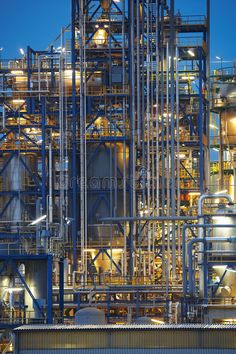 an industrial factory with lots of pipes and tanks at night royalty images - stock photo