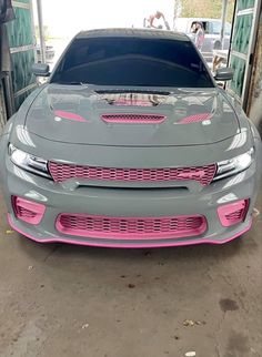 the front end of a gray car with pink stripes